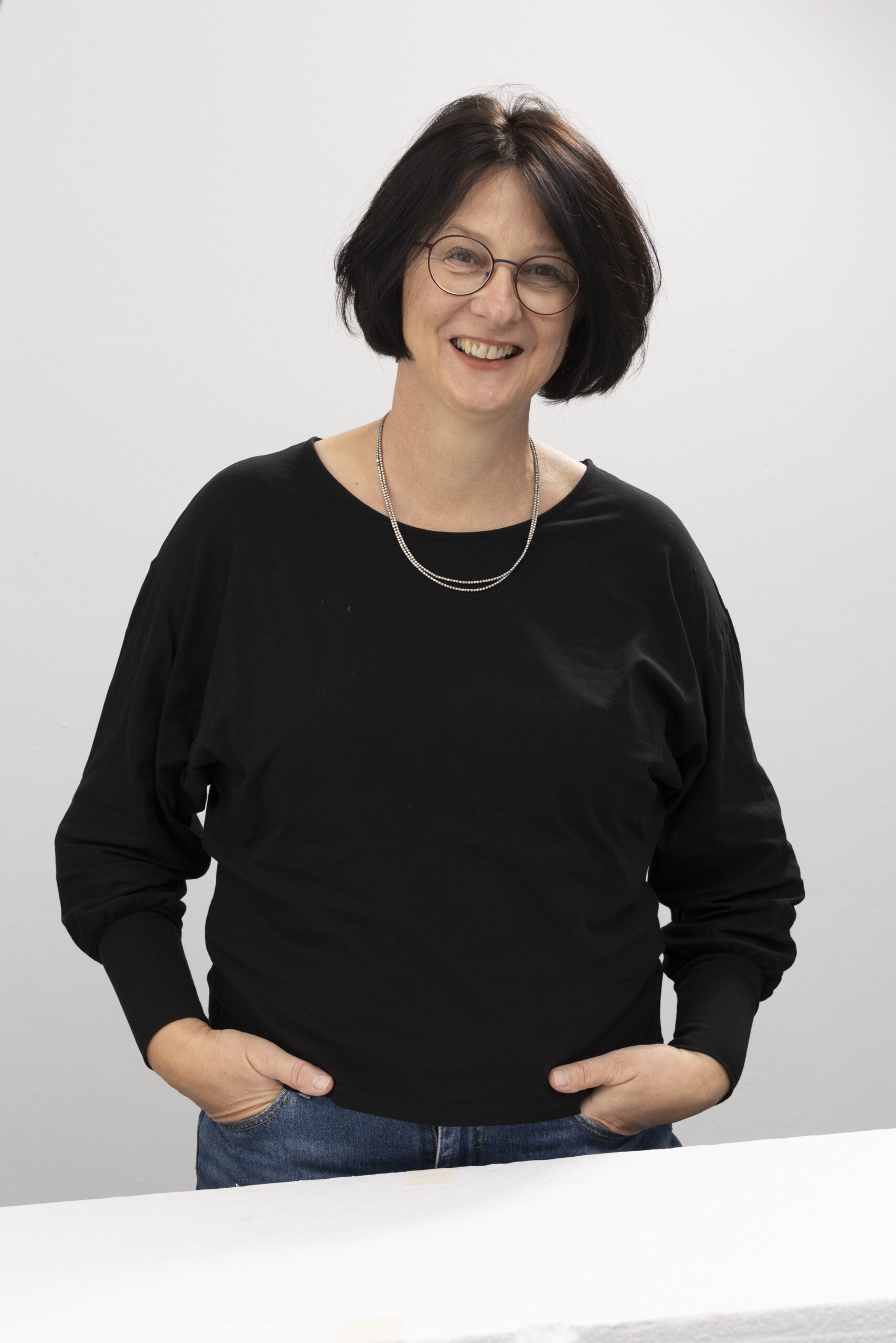 Frauke Lorenzen lächelt in die Kamera, sie hat die Hände in den Hosentaschen und ist Vorstandsmitglied der Denkfabrik.